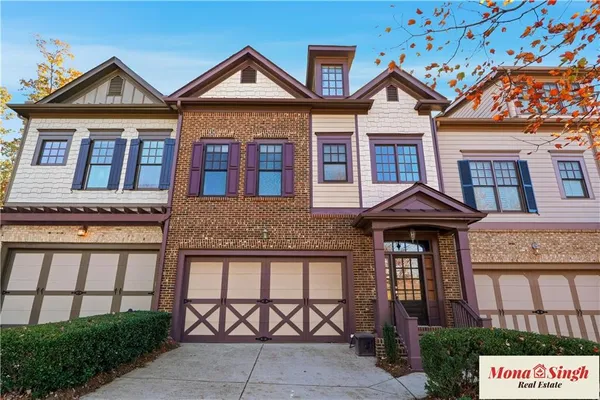 a front view of a residential apartment building with a yard and potted plants