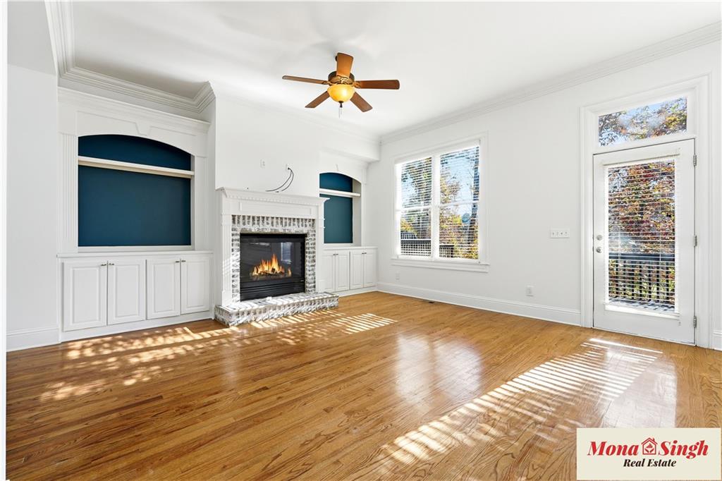 6961 Fellowship Lane Flowery Branch, GA 30542 - Photo 13 of 47 a view of an empty room with wooden floor fireplace and a window