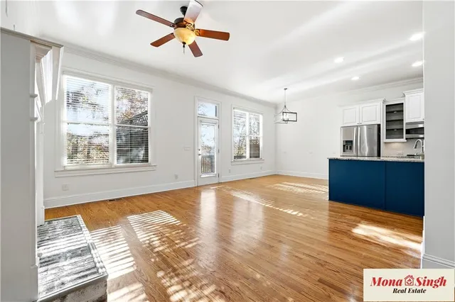 a view of an empty room with window and wooden floor