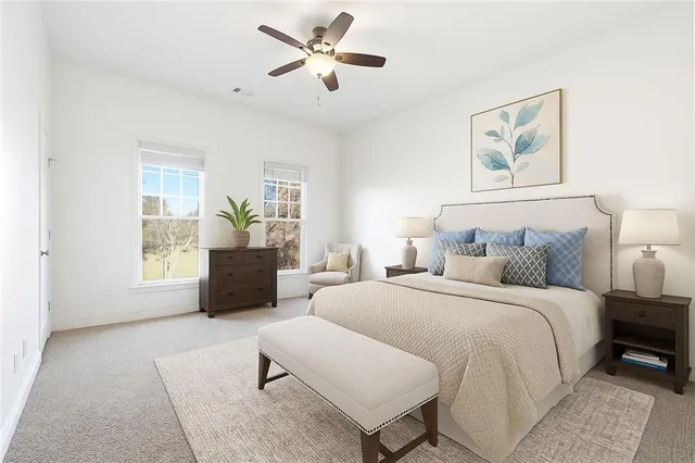 a spacious bedroom with a bed a couch and a chandelier