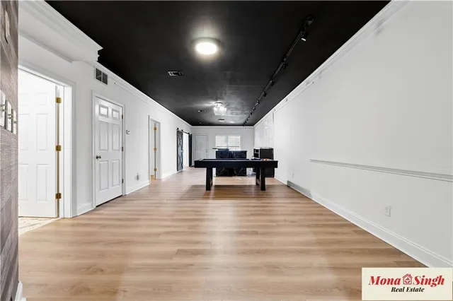 a view of an empty room with wooden floor