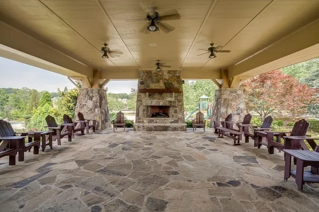 a living room with furniture a fireplace and a floor to ceiling window