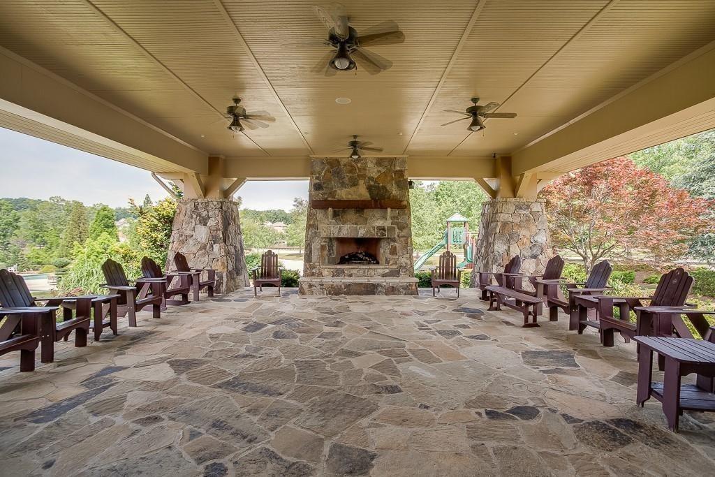 6961 Fellowship Lane Flowery Branch, GA 30542 - Photo 42 of 47 a living room with furniture a fireplace and a floor to ceiling window