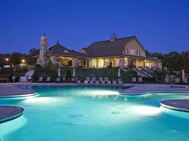 a front view of a house with swimming pool having outdoor seating