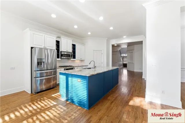 a kitchen with stainless steel appliances granite countertop a refrigerator and a sink
