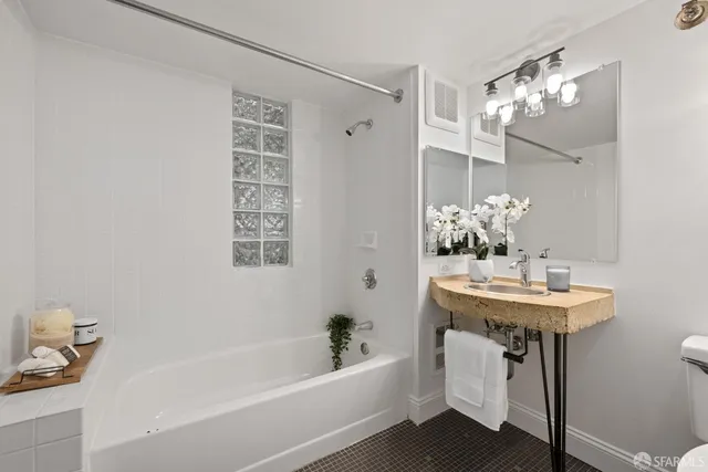 a bathroom with a bathtub a sink and a mirror