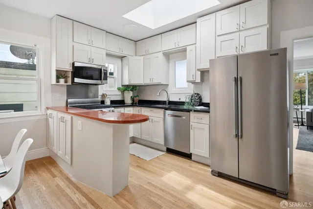 a kitchen with stainless steel appliances a refrigerator stove microwave and sink