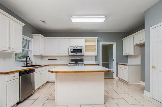a kitchen with stainless steel appliances a sink counter space cabinets and a sink