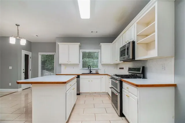 a kitchen with stainless steel appliances granite countertop a sink stove and microwave