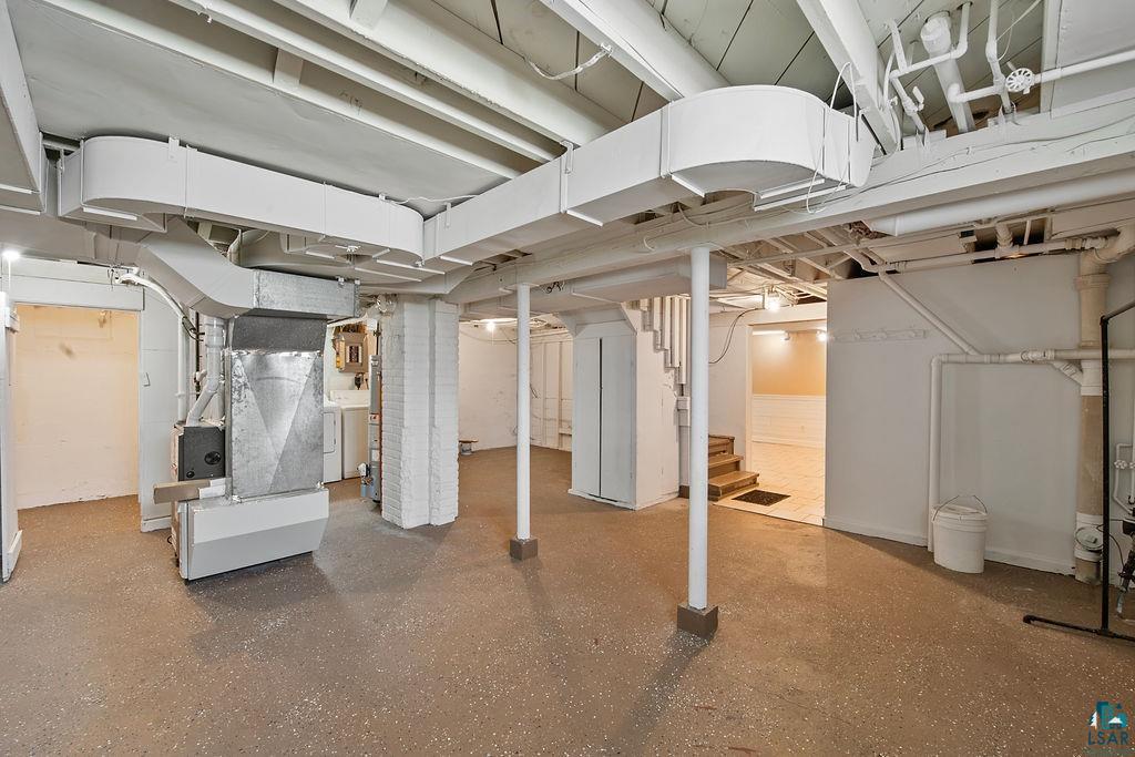 122 3rd Street Cloquet, MN 55720 - Photo 24 of 42 Spacious unfinished basement featuring exposed ceiling joists and ductwork, multiple support columns, painted brick column, and visible mechanical systems