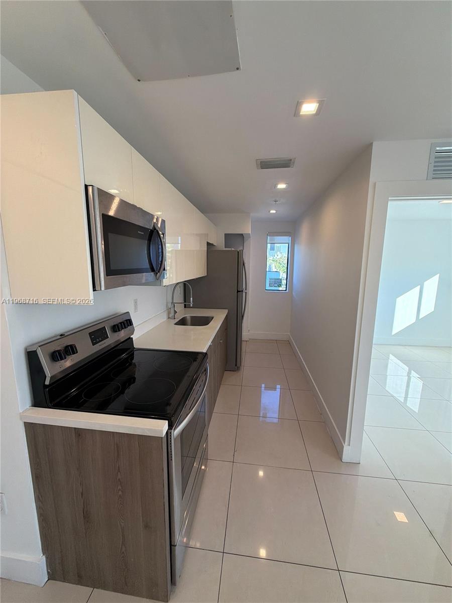 829 Southwest 18th Avenue, Unit 311 Miami, FL 33135 - Photo 2 of 11 a kitchen with a sink and cabinets