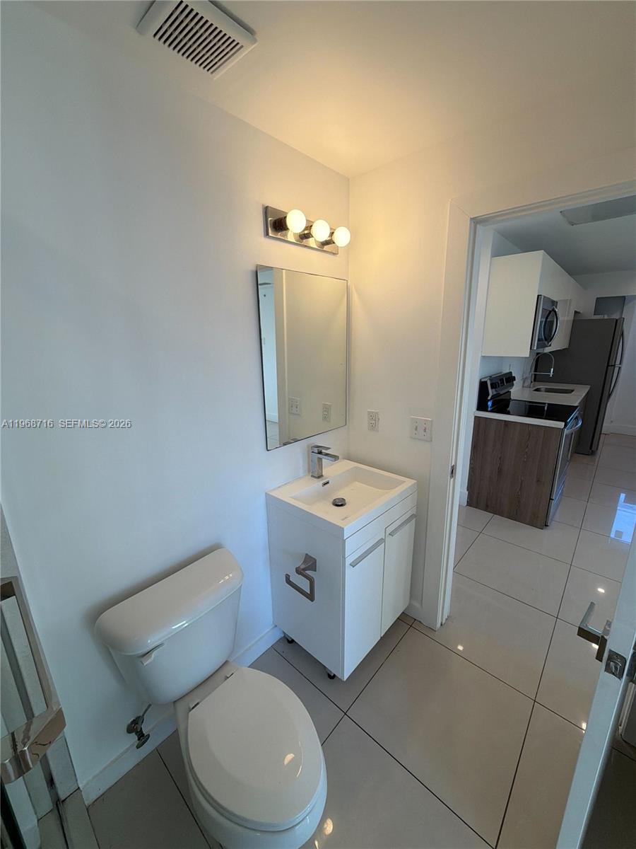 829 Southwest 18th Avenue, Unit 311 Miami, FL 33135 - Photo 7 of 11 a bathroom with a sink a toilet and mirror