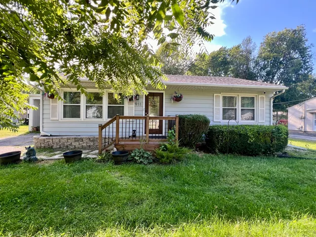 a front view of a house with a yard and trees