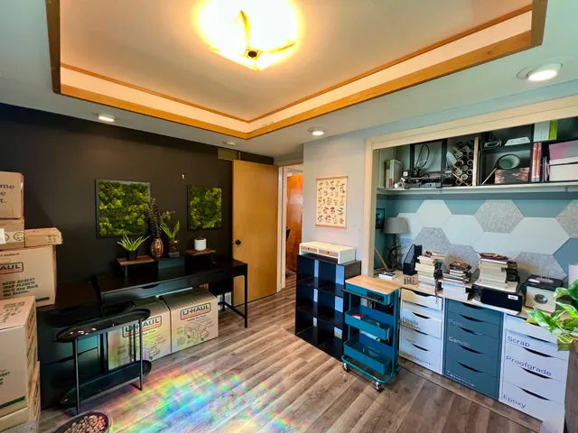 a kitchen with stainless steel appliances kitchen island granite countertop a refrigerator a stove top oven a dining table and chairs with wooden floor