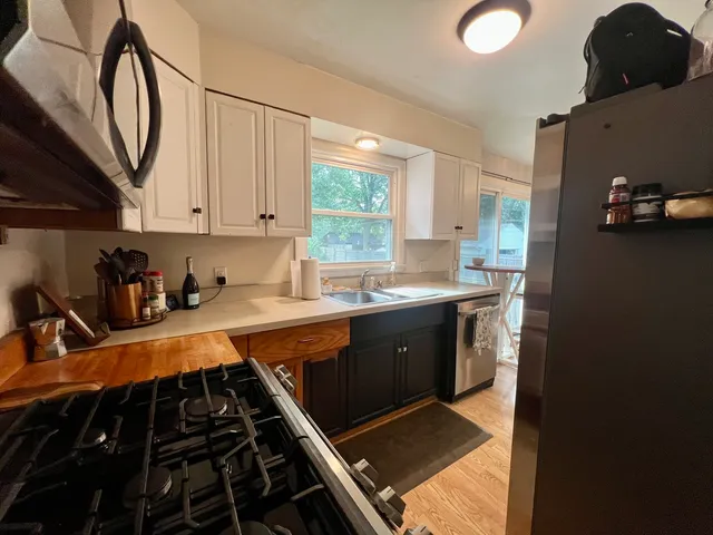 a kitchen with stainless steel appliances a sink stove and cabinets