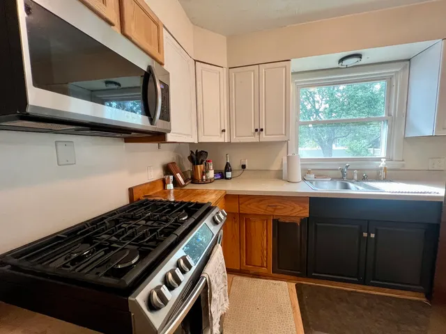 a kitchen with stainless steel appliances a sink stove and cabinets