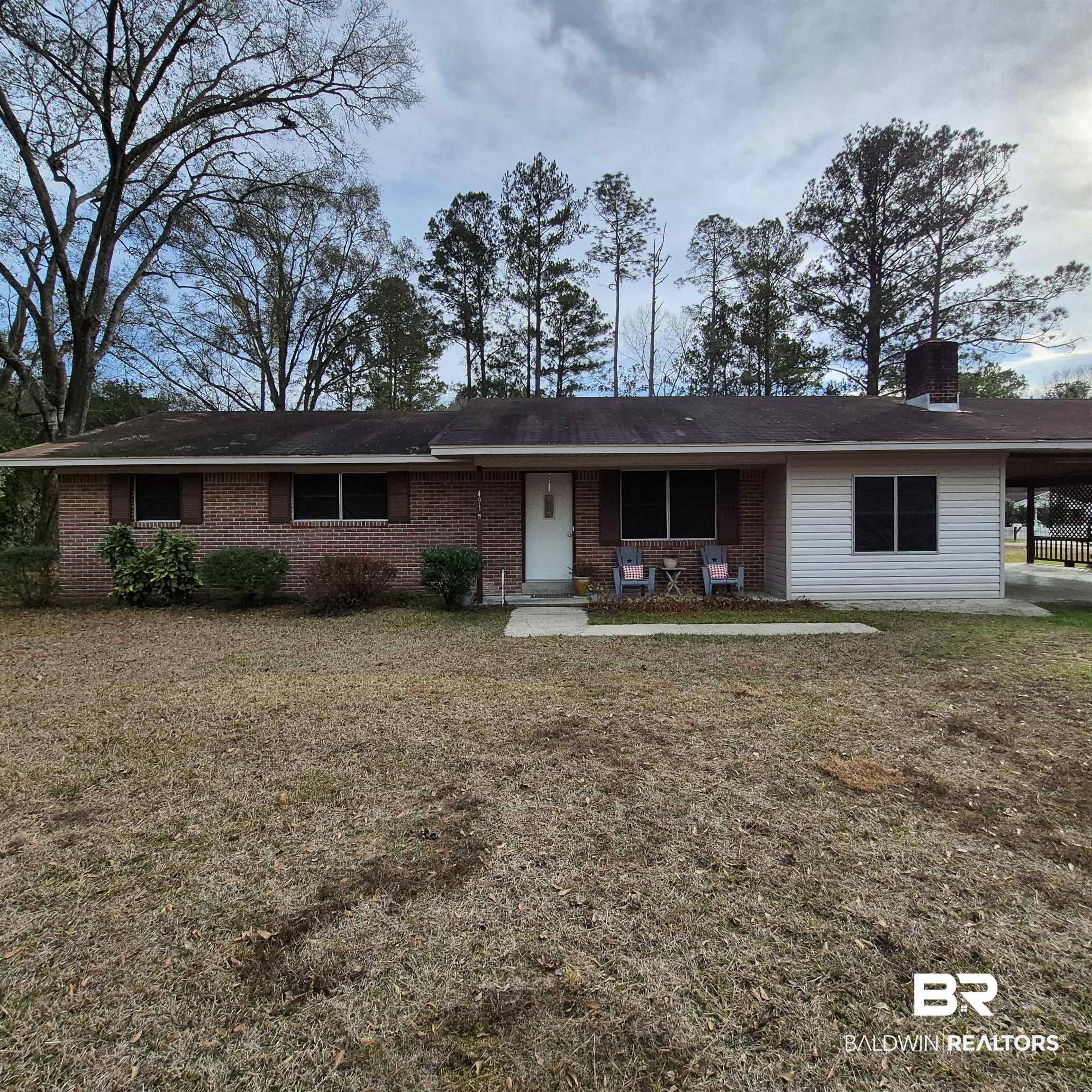 491 Forrest Avenue Castleberry, AL 36432 - Photo 33 of 33 Ranch-style home featuring brick siding, a chimney, a front lawn, a carport, and covered porch