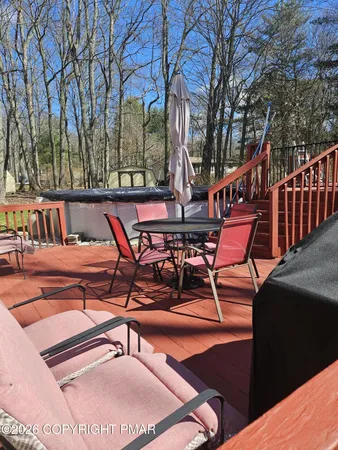 a roof deck with table and chairs and potted plants