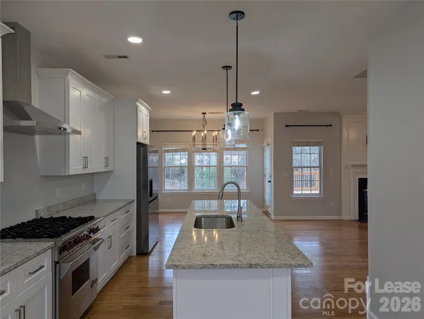 a kitchen with kitchen island granite countertop a sink a counter space appliances and cabinets