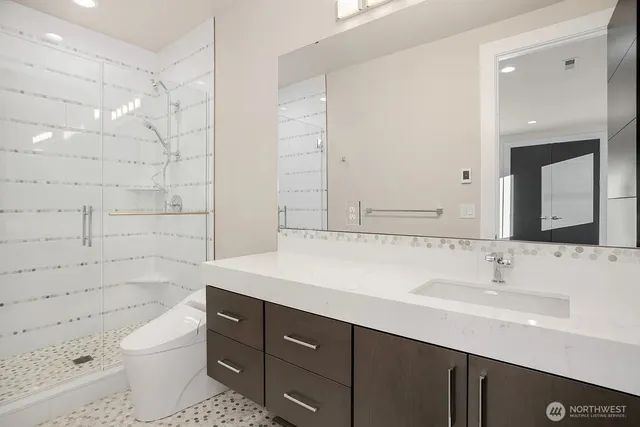 a bathroom with a sink a toilet and shower