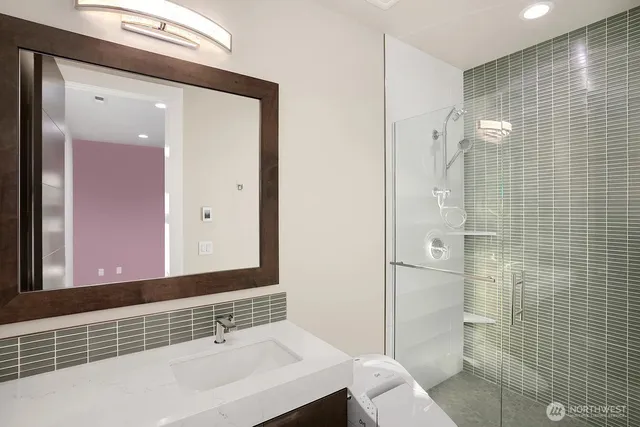 a bathroom with a sink a toilet and shower