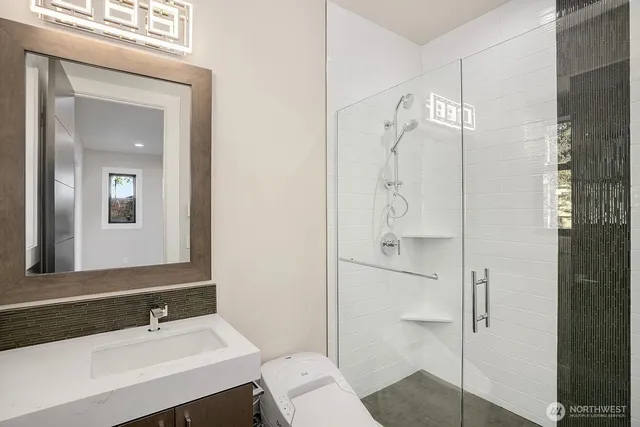 a bathroom with a shower sink and mirror