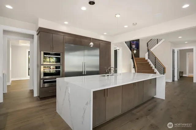 a large kitchen with kitchen island a sink stainless steel appliances and cabinets