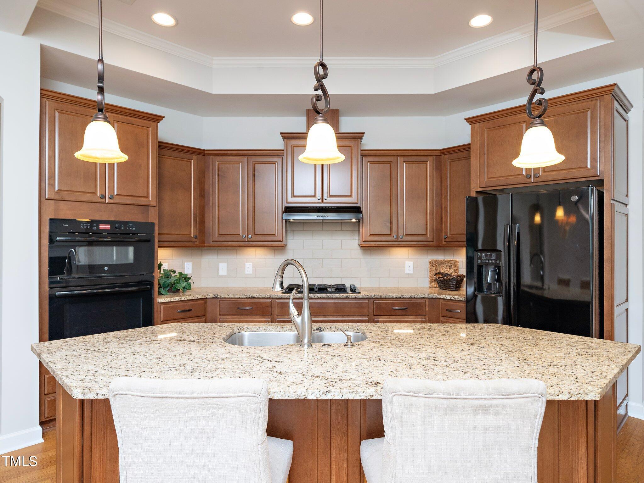 1356 Prevenient Drive Wake Forest, NC 27587 - Photo 11 of 27 a kitchen with kitchen island granite countertop a sink a counter top space appliances and cabinets