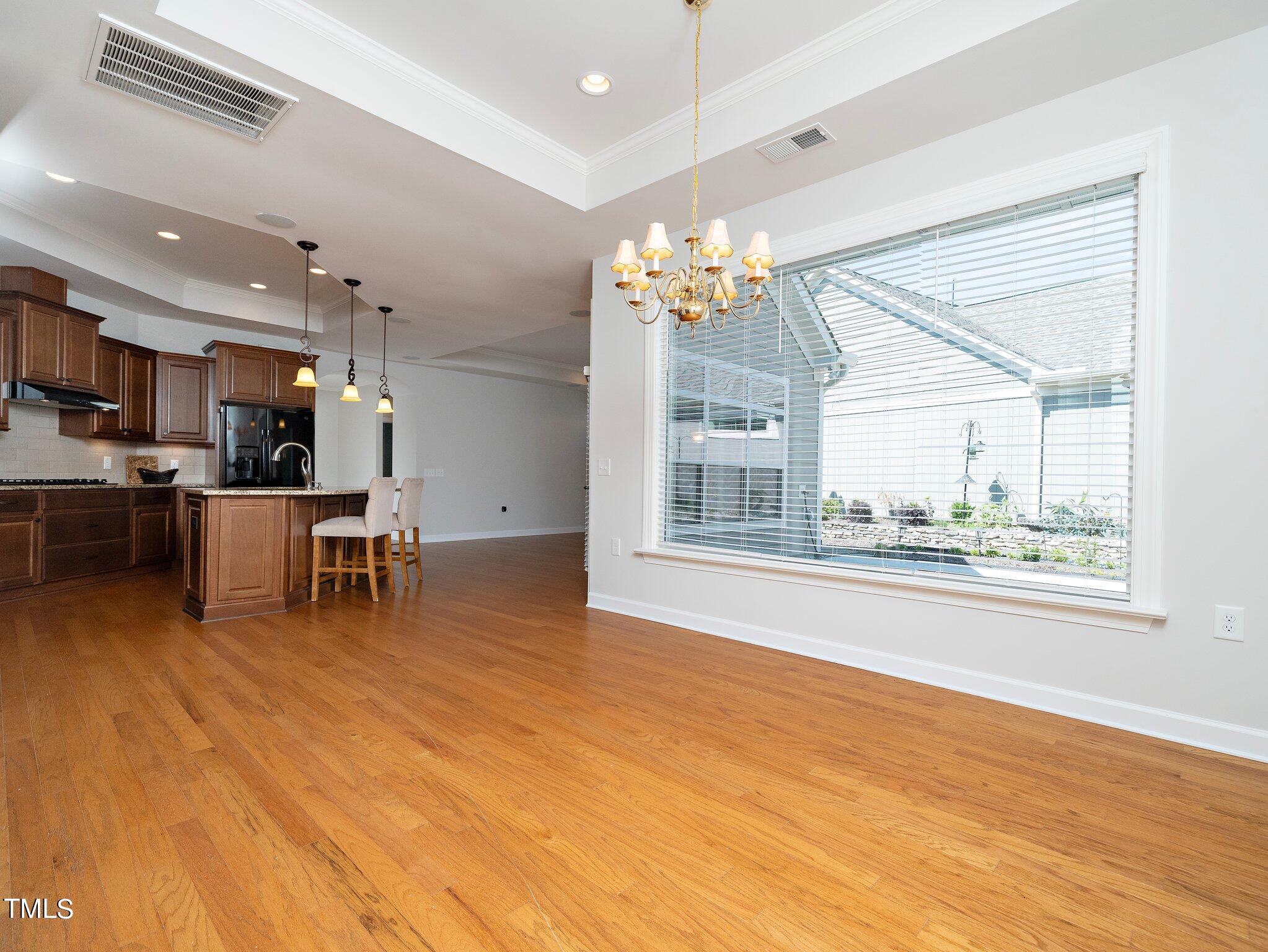 1356 Prevenient Drive Wake Forest, NC 27587 - Photo 14 of 27 a view of a room with kitchen island stainless steel appliances wooden floor and windows