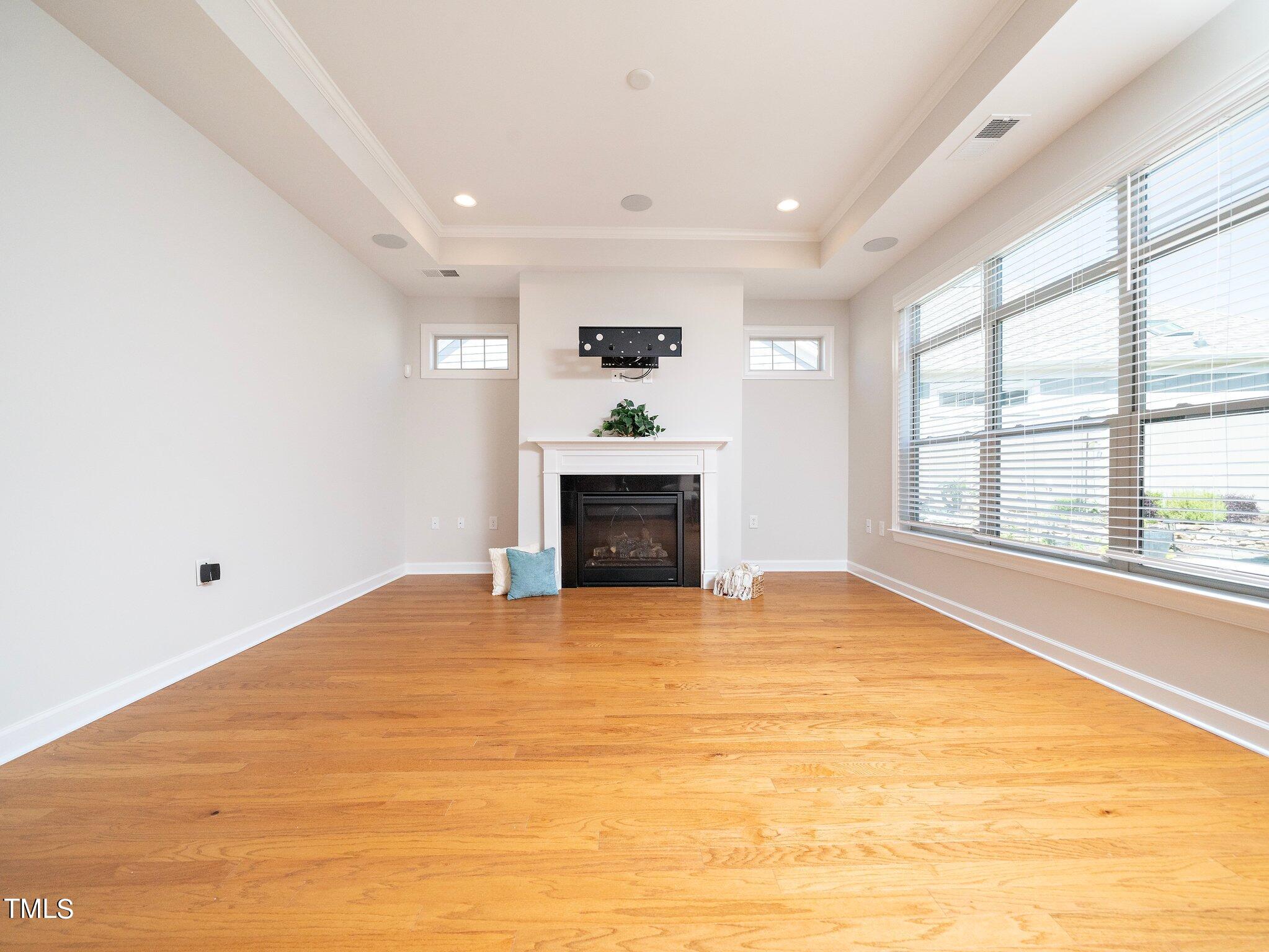 1356 Prevenient Drive Wake Forest, NC 27587 - Photo 8 of 27 a view of an empty room with a fireplace and a window
