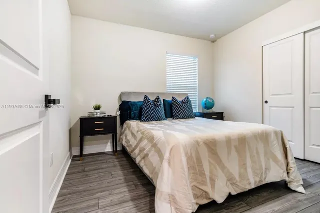 a bedroom with a bed and wooden floor