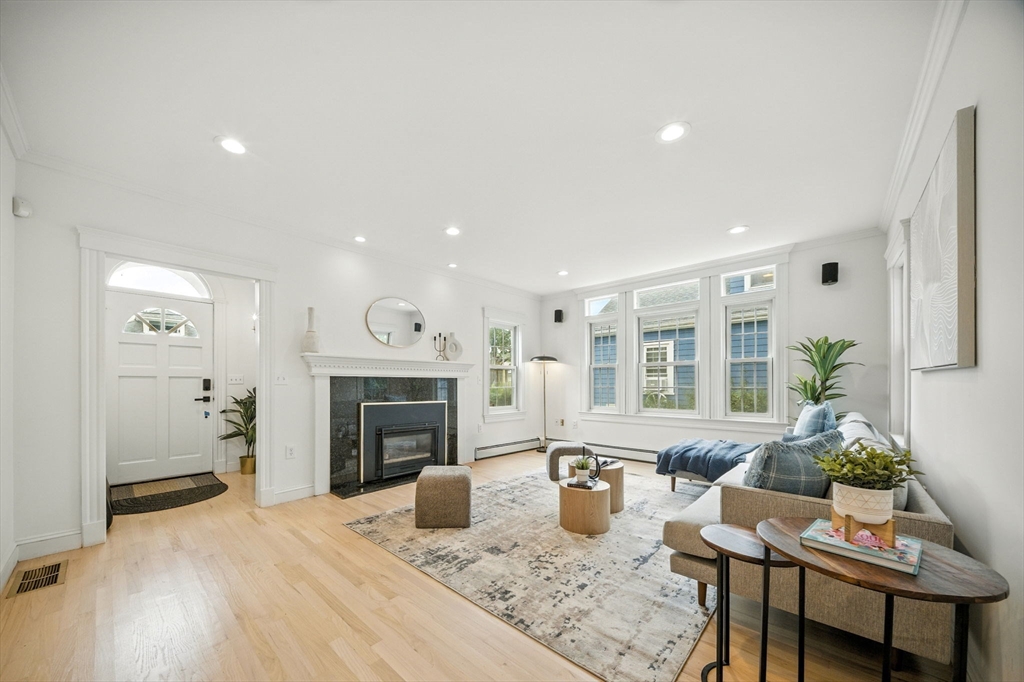11 Dana Road Newton, MA 02465 - Photo 2 of 35 a living room with furniture a fireplace and a open kitchen view