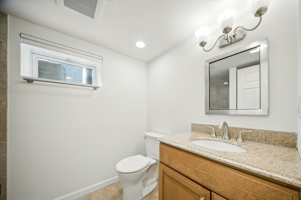 11 Dana Road Newton, MA 02465 - Photo 31 of 35 a bathroom with a granite countertop sink mirror vanity and toilet