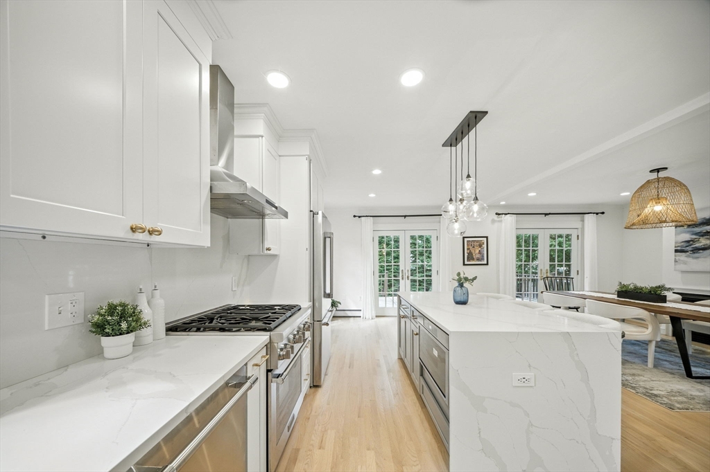 11 Dana Road Newton, MA 02465 - Photo 8 of 35 a large kitchen with stainless steel appliances a large counter top a stove a chimney a sink and a refrigerator