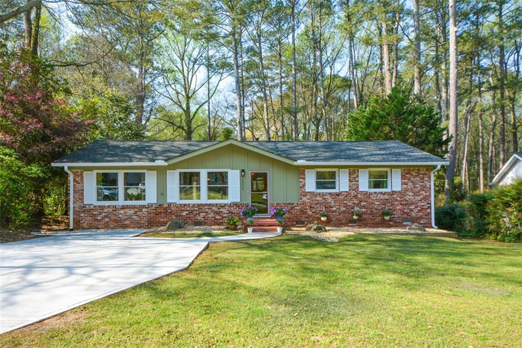 a front view of a house with yard porch and tree