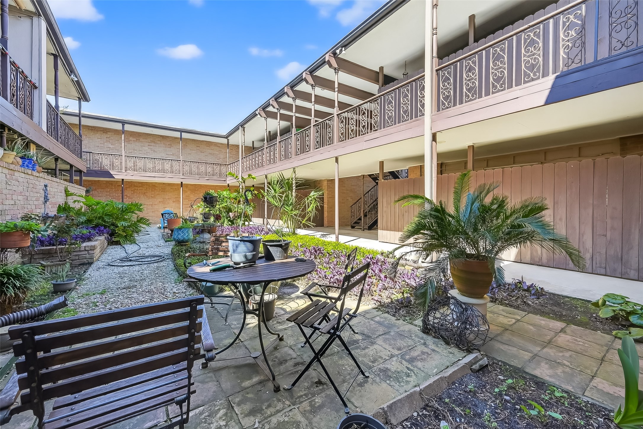 2516 Commonwealth Street, Unit 203 Houston, TX 77006 - Photo 2 of 16 The beautifully landscaped courtyard creates a peaceful garden retreat, featuring lush plantings, shaded seating areas, and charming brick surroundings—an inviting space to relax or enjoy morning coffee just steps from your door.