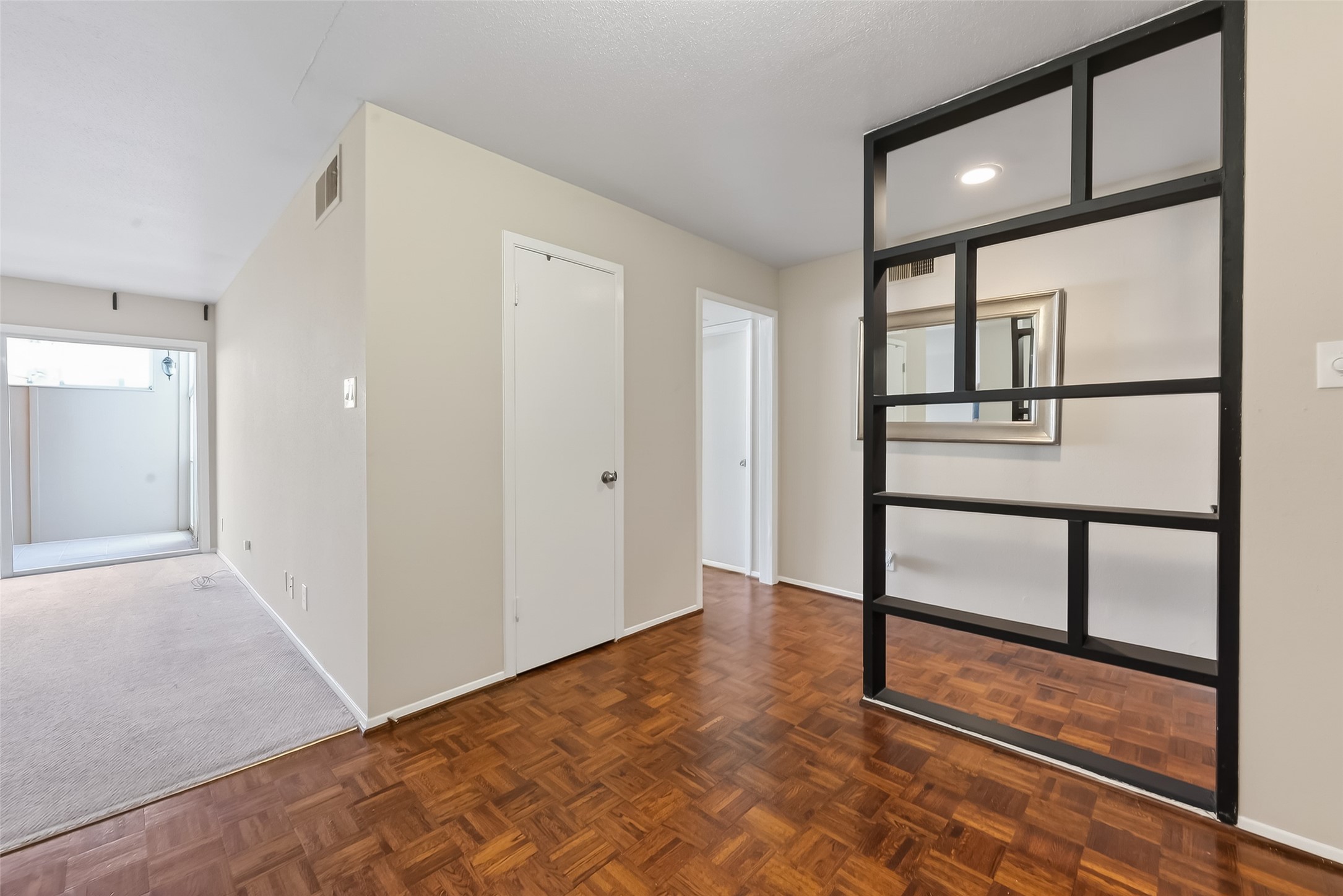 2516 Commonwealth Street, Unit 203 Houston, TX 77006 - Photo 6 of 16 The dining area opens seamlessly into the living space, creating a comfortable open layout. Decorative shelving provides a stylish divider, while the doorway to the right leads to the private bedroom area.