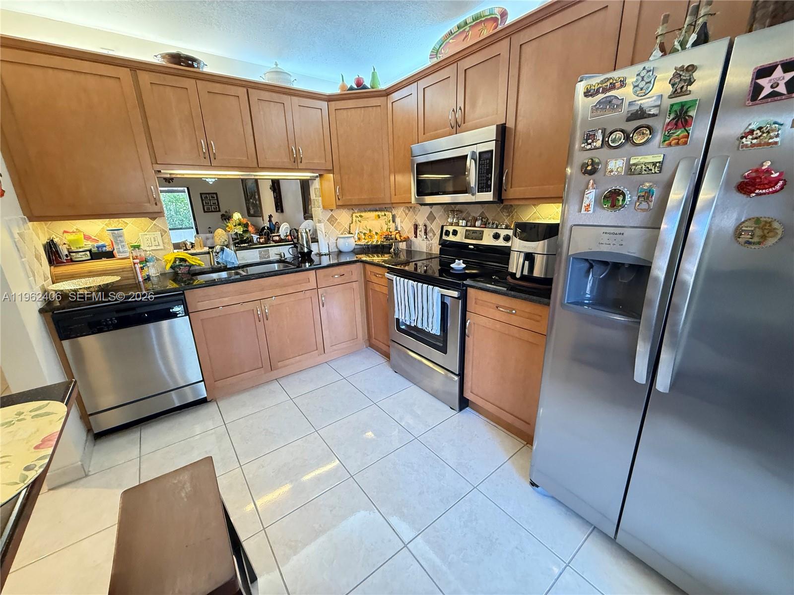 351 Club Circle, Unit 102 Boca Raton, FL 33487 - Photo 10 of 34 a kitchen with stainless steel appliances granite countertop a refrigerator stove and sink