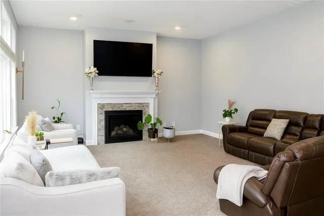 a living room with furniture a flat screen tv and a fireplace