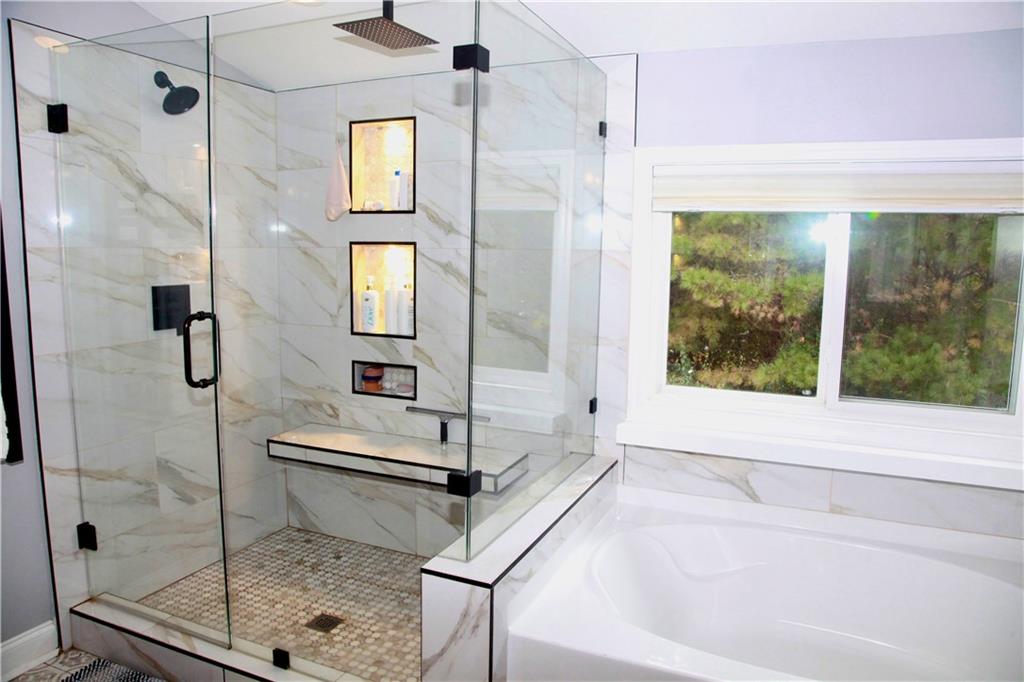 830 Commerce Trail Canton, GA 30114 - Photo 24 of 32 a bathroom with a tub and a shower