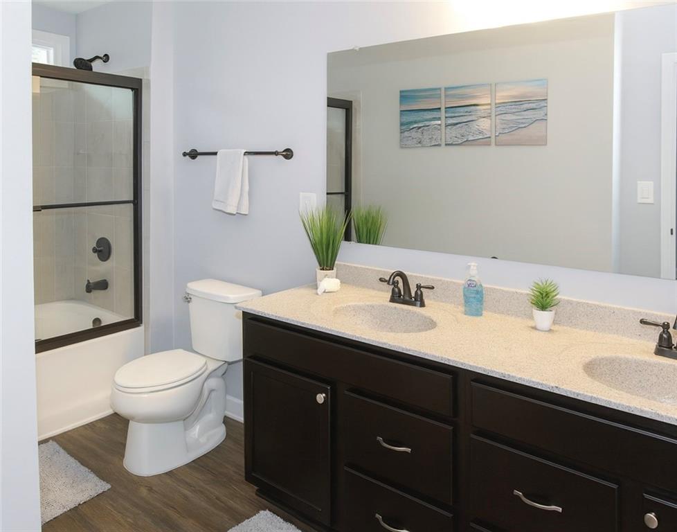 830 Commerce Trail Canton, GA 30114 - Photo 29 of 32 a bathroom with a granite countertop toilet sink and a mirror