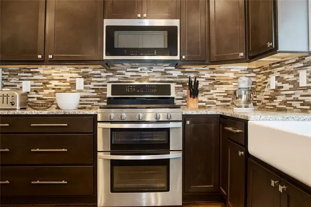 a kitchen with granite countertop a stove and a microwave