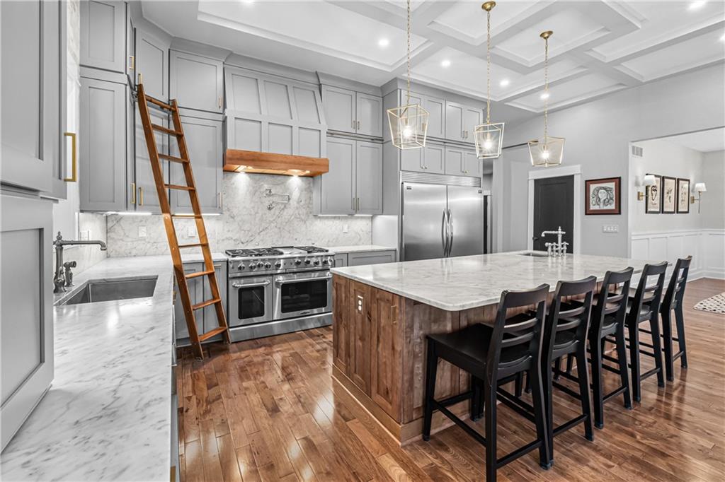 211 McMichael Road Carnegie, PA 15106 - Photo 9 of 50 a kitchen with stainless steel appliances granite countertop a stove top oven a sink dishwasher and a dining table with wooden floor