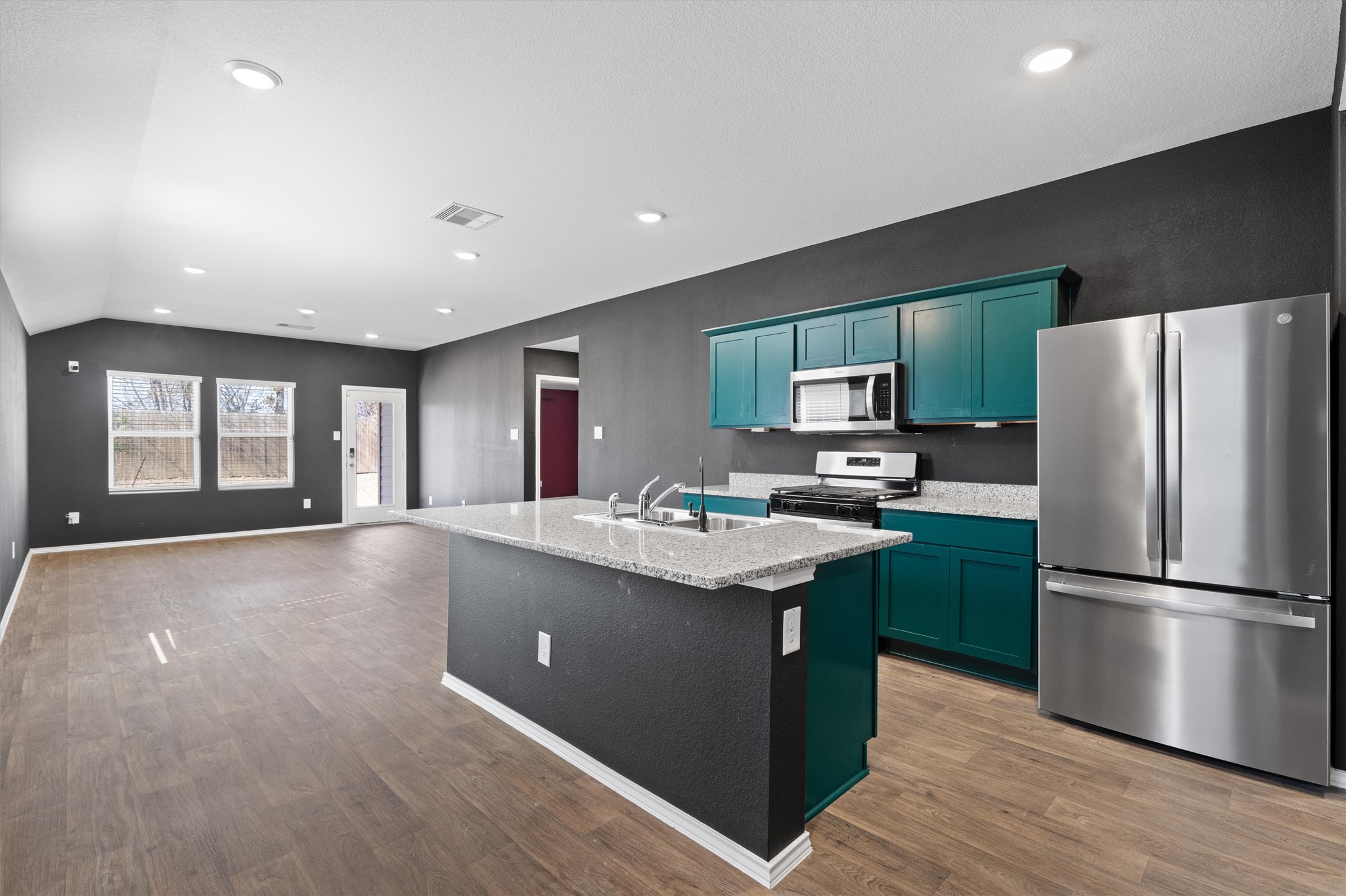 352 Sickle Loop Uhland, TX 78640 - Photo 11 of 36 Kitchen island with breakfast bar seating and open view to living area.