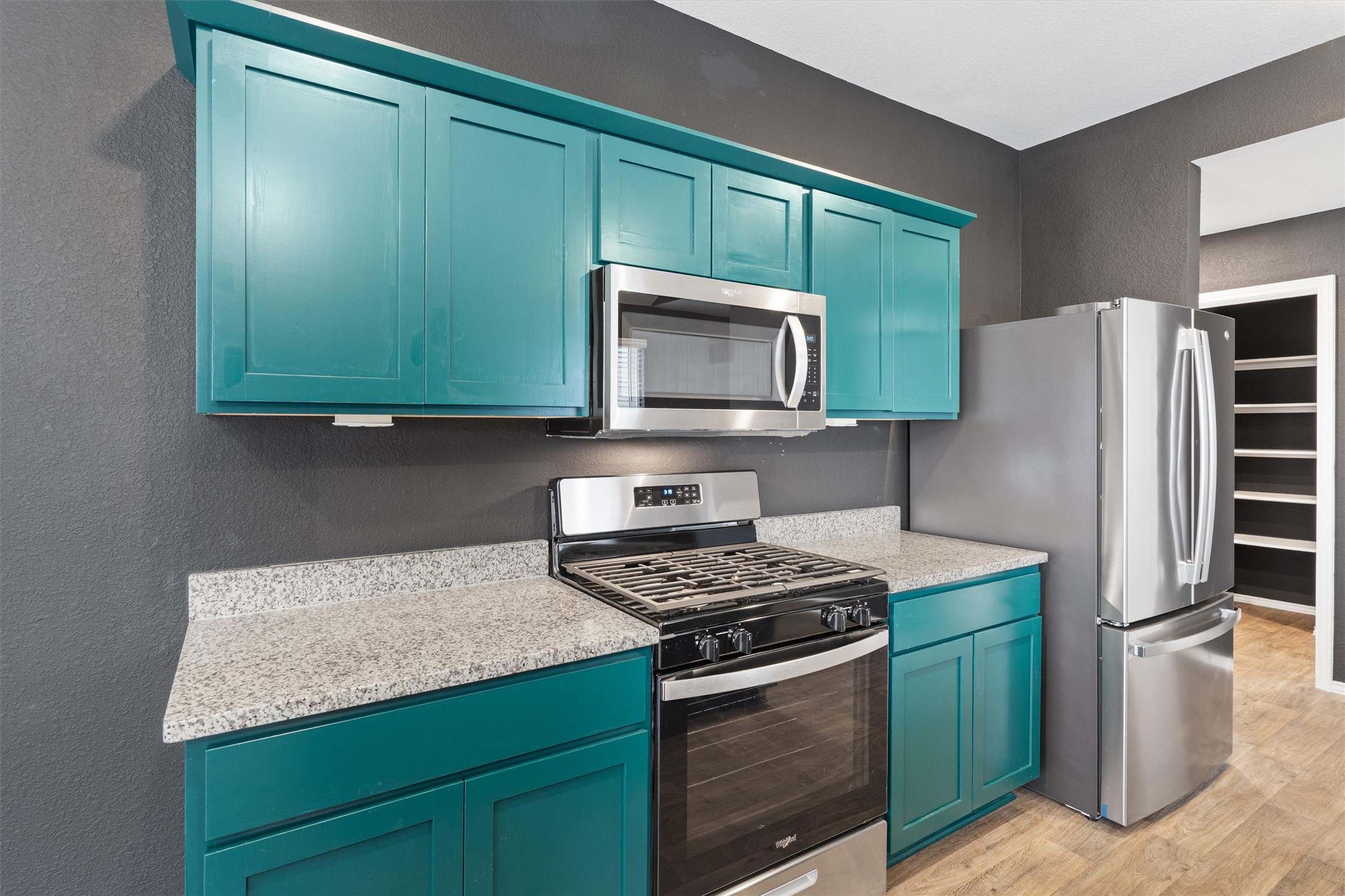 352 Sickle Loop Uhland, TX 78640 - Photo 12 of 36 Kitchen with bold cabinetry, granite countertops, and recessed lighting.