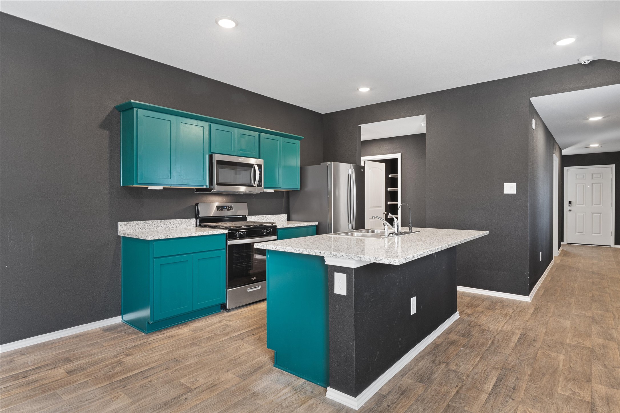 352 Sickle Loop Uhland, TX 78640 - Photo 9 of 36 Open kitchen featuring granite countertops, gas range, stainless steel appliances, and center island.