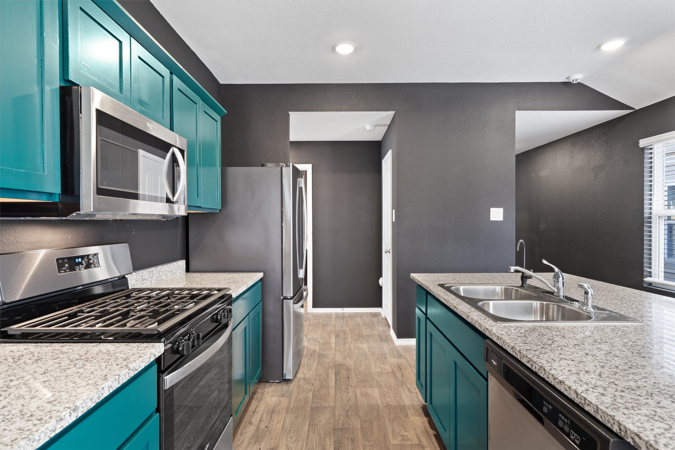 352 Sickle Loop Uhland, TX 78640 - Photo 10 of 36 Kitchen with bold cabinetry, granite countertops, and recessed lighting.
