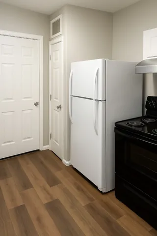 a view of empty room with wooden floor and cabinets
