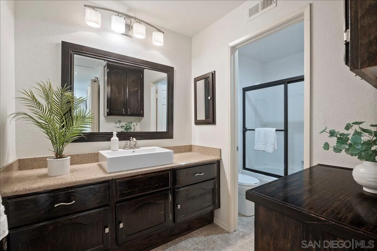 2315 Rancho Del Oro Drive, Unit 14 Oceanside, CA 92056 - Photo 13 of 34 a bathroom with a sink a vanity and a mirror