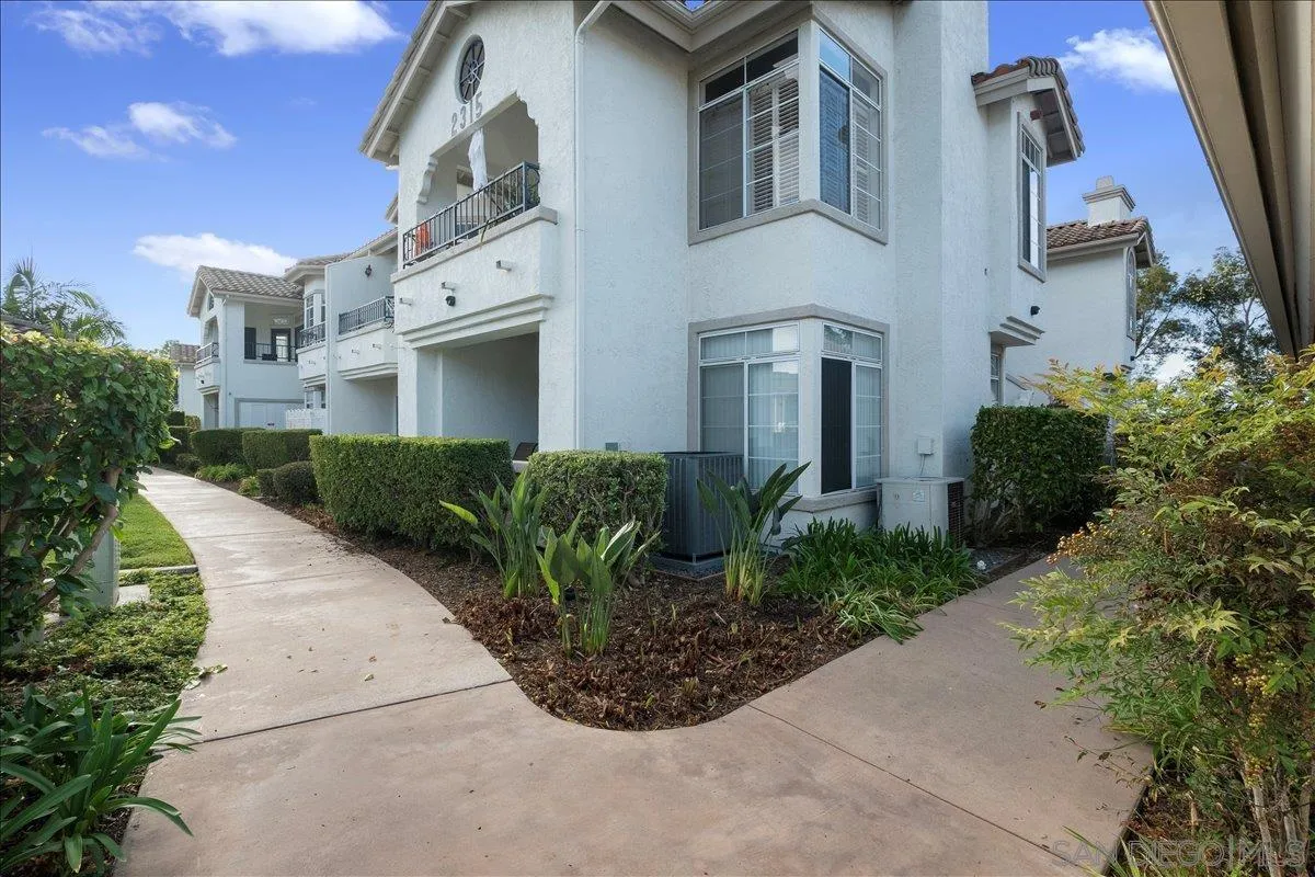 2315 Rancho Del Oro Drive, Unit 14 Oceanside, CA 92056 - Photo 27 of 34 a front view of a multi story residential apartment building with yard and parking
